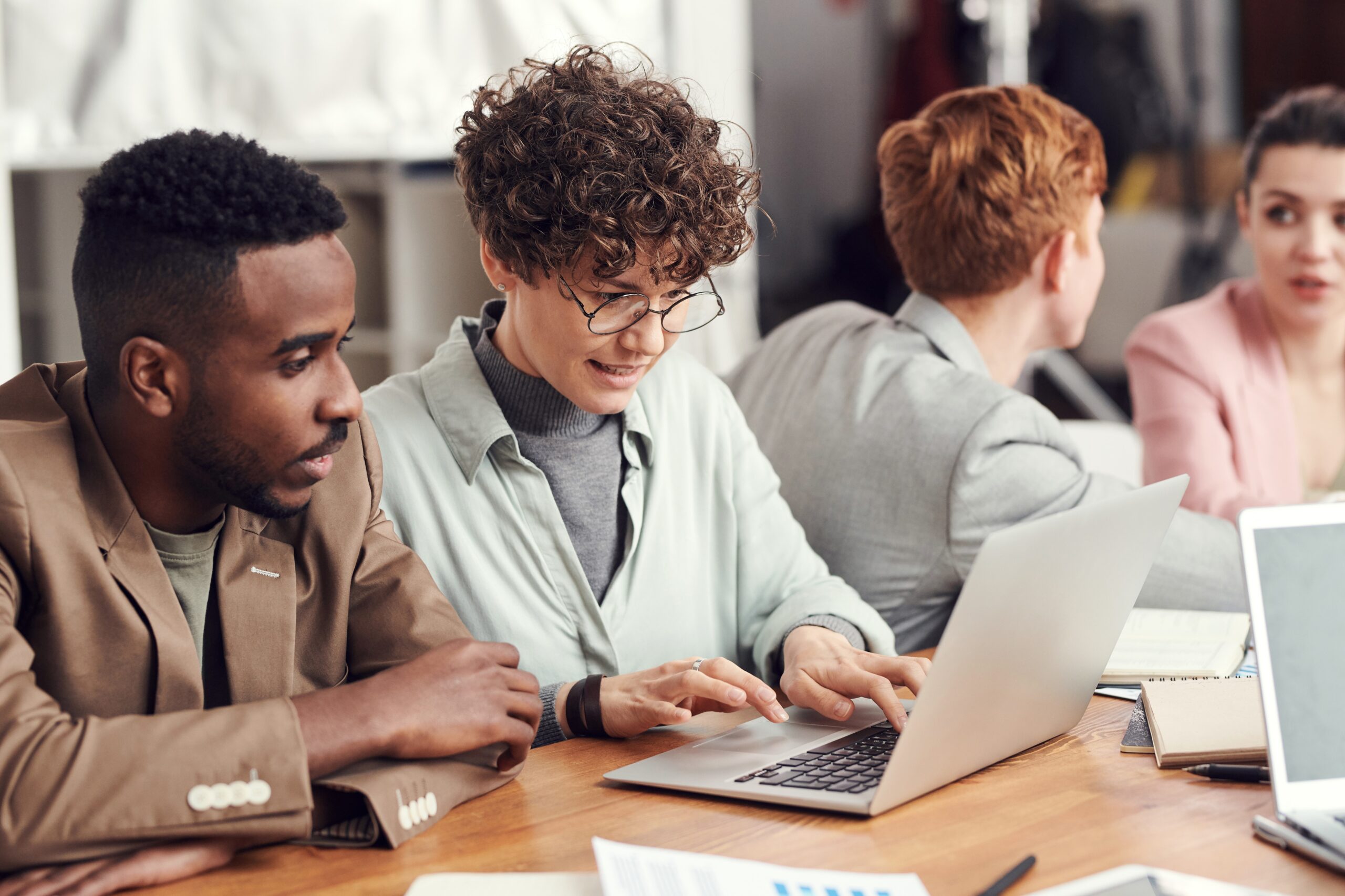 Gruppe arbeitender Berater vor Laptop