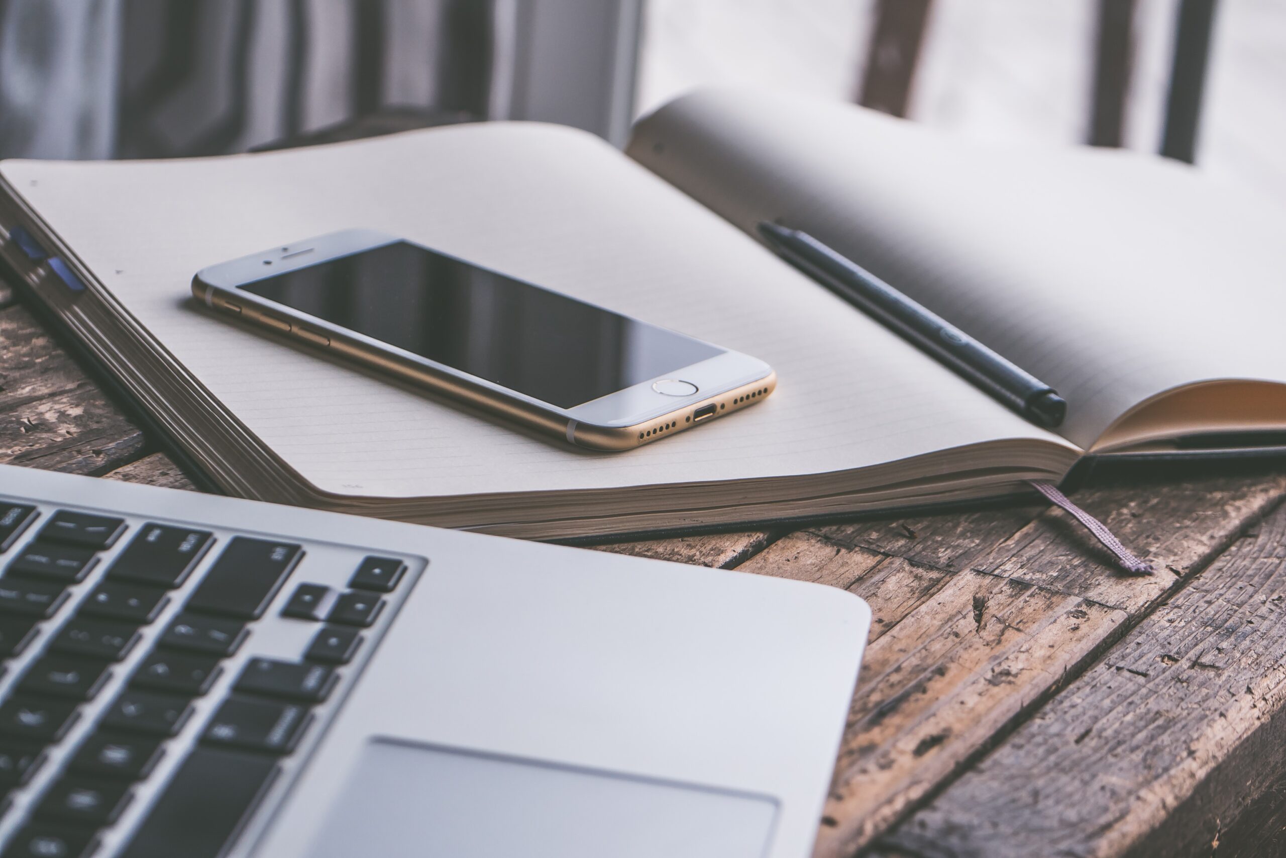 laptop, telefon und buch auf tisch